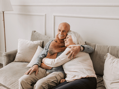 Happy senior couple embracing on couch